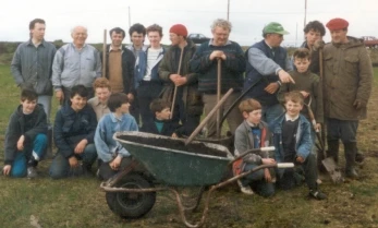 Men and Boys at work on the football pitch.
