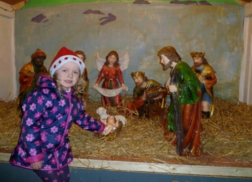 Marie McNulty places the Baby Jesus in the Crib at Bullsmouth School.